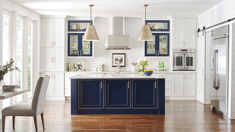 A modern kitchen design showcasing a bold navy blue island, contrasting with white cabinets and geometric backsplash, creating a fresh and contemporary feel.