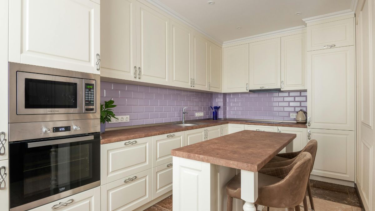 A modern kitchen featuring purple tile flooring and sleek white cabinets, creating a vibrant and stylish atmosphere.