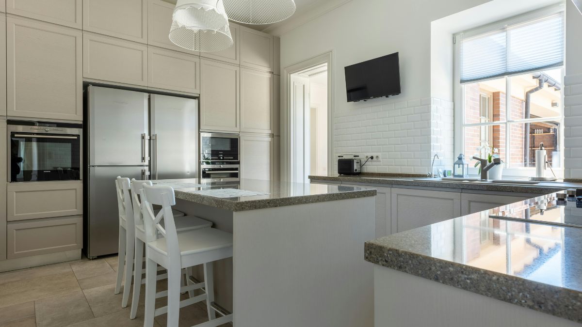 A modern kitchen featuring a spacious island and sleek stainless steel appliances, showcasing a clean and organized space.