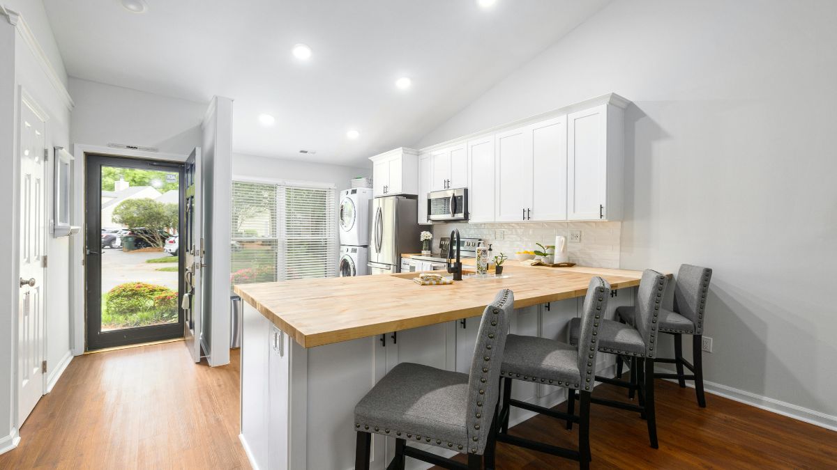 A modern kitchen featuring a wooden island complemented by stylish bar stools for casual dining.